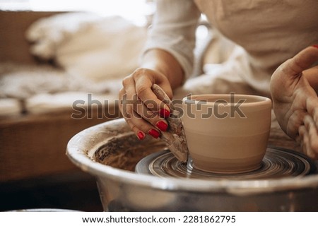 Woman working on pottery wheel creating a bowl