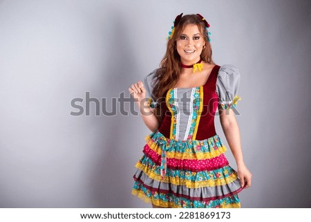 Beautiful Brazilian woman, wearing country clothes, for Festa de São João, Festa Junina. Posing for photo. Half body photo.