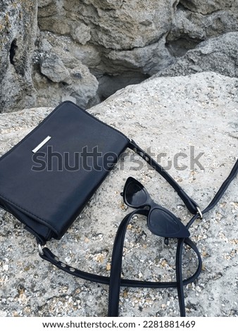 
Fashion photo of bags and glasses. Sea ​​objects on the background of stones