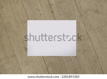 The flat top view of a4 blank white horizontal page isolated on wooden background with a diagonal line, for business quote inspiration presentation or branding identity information design mockup.