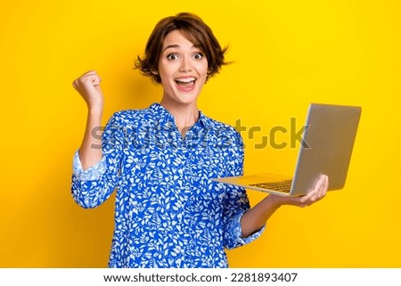 Photo of positive cheerful lady wear blue trendy clothes rise hand fist rejoice special offer isolated on yellow color background