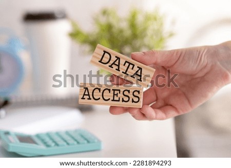 Data Access text written on a wooden block in hands, glasses and calculator Business concept.