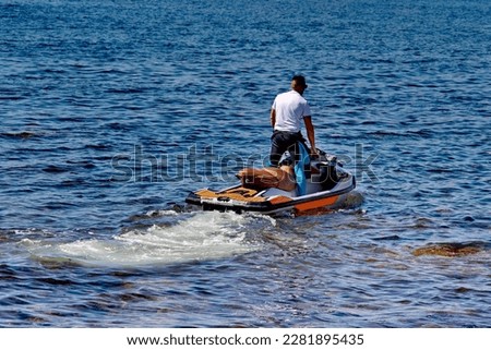 A man sets off on an adventure at sea, riding his jet ski with the wind in his hair. Thrill-seekers can capture the excitement of water sports with our collection of jet ski photos