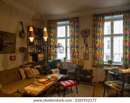 Step into the past with this cluttered, yet charming living room from a 1960's Copenhagen apartment. Experience the retro ambiance of a bygone era. Royalty-Free Stock Photo #2281922177