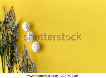 Easter white chicken painted eggs with a bunny on a bright yellow background and with a bouquet of violet flowers. Easter holiday, minimalism, spring composition. Free copy space for text.
