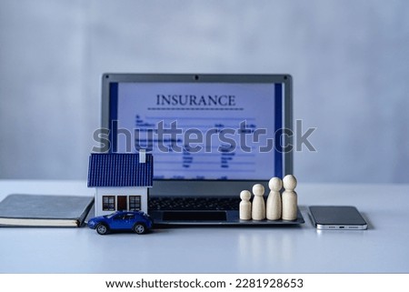 Car house, wooden dummy, laptop on table, white background, insurance concept.