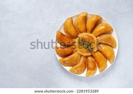 Traditional arabic ramadan sweets qatayef . Middle estern semolina pancakes filled with nuts and cheese. Top view , copy space Royalty-Free Stock Photo #2281953289