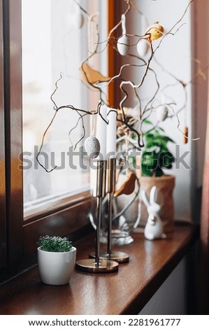 Easter decor on twigs, candles and young watercress sprouts on the windowsill.