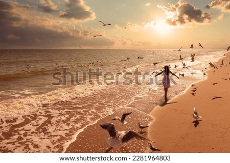 Seascape during sunrise with beautiful sky. Woman on the beach, summertime. Young happy woman with hands in the air walks on the seaside in dress. Seagulls flying on the beach. #uniquesself Royalty-Free Stock Photo #2281964803