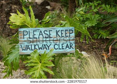 friendly "Please keep walkway clear" sign in the garden