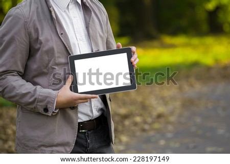 Man holding a digital tablet pc at the park.
