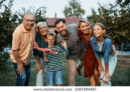 Happy multigeneration family in the backyard looking at camera. Royalty-Free Stock Photo #2281984487