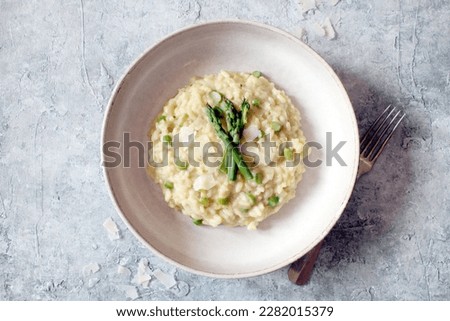 Italian risotto with asparagus and parmesa cheese on table. Top view. Royalty-Free Stock Photo #2282015379