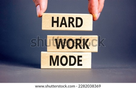 Hard work mode symbol. Concept words Hard work mode on wooden block on a beautiful grey table grey background. Businessman hand. Business and Hard work mode concept. Copy space.