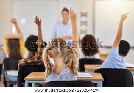 Answering, back and children raising hand in class for a question, answer or vote at school. Teaching, academic and a student asking a teacher questions while learning, volunteering or voting Royalty-Free Stock Photo #2282044199