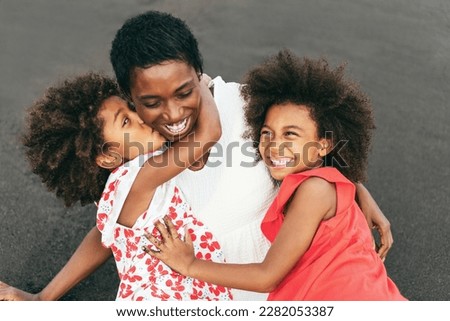 African sisters having fun with their mother on the beach - Focus on right girl hand - Mom day and love concept