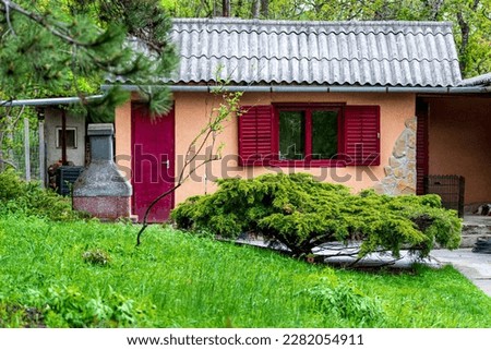 weekend house with red window in a garden in spring.