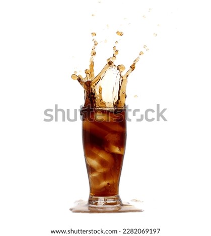 Ice Coffee Drink and Ice Tea tall glass splash up in Air. Cold brew ice coffee tea in cool glass drop splash and spill out of glass. White background isolated, high speed shutter freeze motion