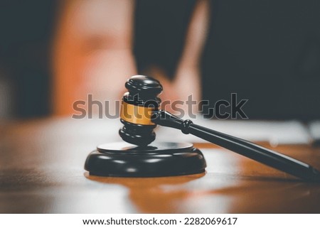 Close-up Of Gavel on sounding block and Male Judge Writing On Paper in office,advice and justice concept