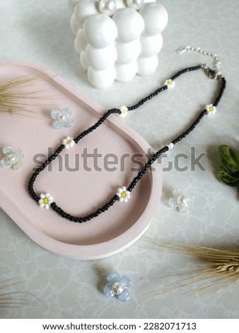 Black beaded necklace with white and yellow floral motif