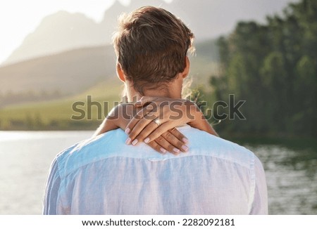 Engagement, hug and couple by lake for romantic holiday, vacation and honeymoon in nature together. Love, proposal mockup and hands of woman holding man for embrace, hugging and affection outdoors Royalty-Free Stock Photo #2282092181