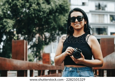 Photograph of photographer holding her reflex camera. Lifestyle concept and professions.