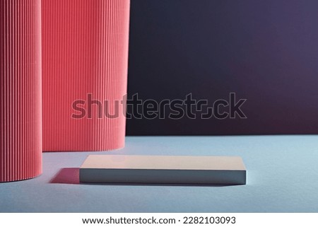Front view of white rectangle empty podium on dark background. Pink paper folds form a soft undulating wall. Abstract background for branding and minimal presentation.