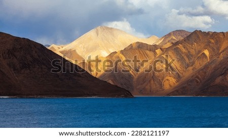 Beautiful panorama landscape of Pangong lake with mountain background without trees.Sunlight in morning or evening with blue colorful lake.Landscape of Ladakh,North India in winter.Nobody picture.
