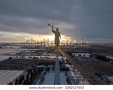 Forward facing closeup sunset shot of Angel Moroni on top of Rexburg Mormon Temple.