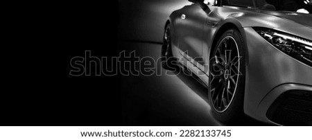 Front headlights of sport roadster  car on black background,black and white, copy space	 Royalty-Free Stock Photo #2282133745