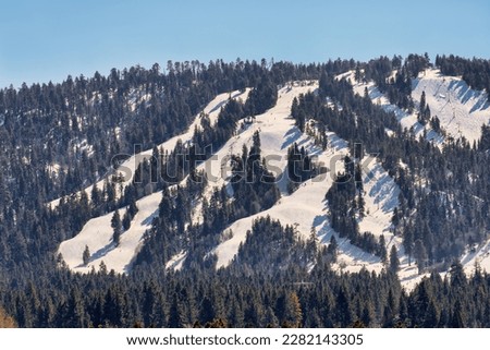 View of snow covered Big Bear Mountain where Snow Summit and Bear Mountain Ski Resorts are located. Big Bear Lake, California USA.