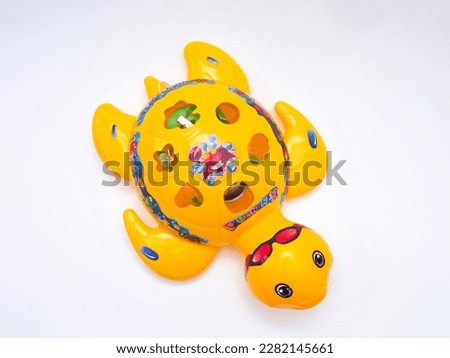 a yellow tortoise toy for children with a white background