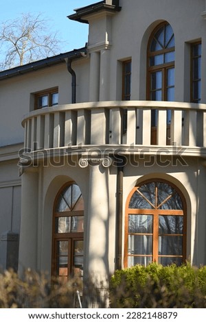 the veranda of a historic residence with a terrace above it