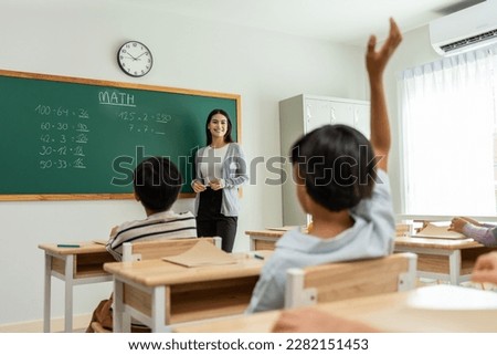 Group of student learn with teacher in classroom at elementary school. Attractive beautiful female instructor master explain and educate young children with happiness and fun activity at kindergarten. Royalty-Free Stock Photo #2282151453