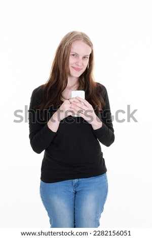 beautiful young blond woman holding mobile phone on heart in jeans pockets casual smiling beautiful slim girl