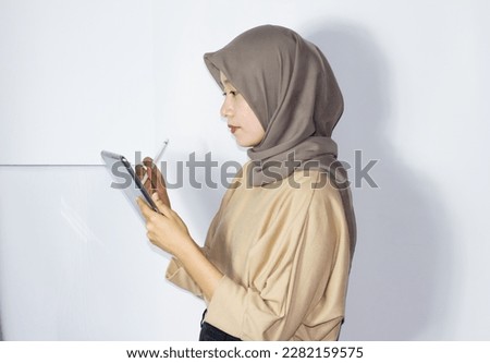 Portrait of young hijab women using tablet