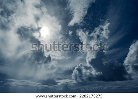 Dramatic cloudscape of various types of clouds with the sun brightly shining from behind the clouds