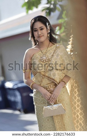 Thai girl with modern traditional costume dresses at Thai beautiful temple in Bangkok, Thailand