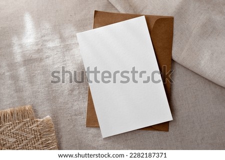 Classic minimalist business brand template, blank paper card and envelope on a neutral beige background with sunlight shadows, copy space