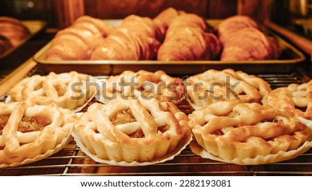 Delicious Baked Apple Pies And Croissants on A Metal Grates Ready To Serve. 