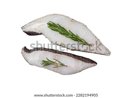 Raw halibut fish steak in wooden tray with herbs. Isolated on white background