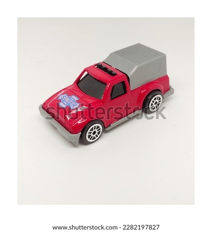 a toy car in red and gray on a white background
