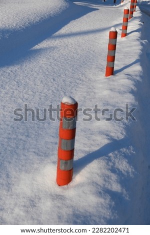 reflective pillars sticking out of the thick layer of snow
