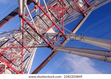 The bottom view of a big ferris wheel with steel frame painted in white and red in Sapporo, Japan. 