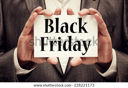 Black Friday written on a card in hands of a businessman