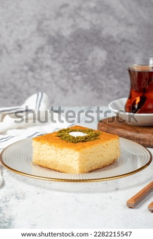 Revani dessert. Sweet semolina cake with pistachio. Ramadan sweets. Traditional Turkish cuisine delicacies. Revani dessert with syrup on a gray background. Royalty-Free Stock Photo #2282215547