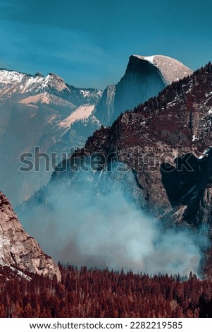 This striking photograph captures the beauty of Yosemite Valley using infrared photography. Smoke from a fire burning inside the valley adds an eerie element to the scene.