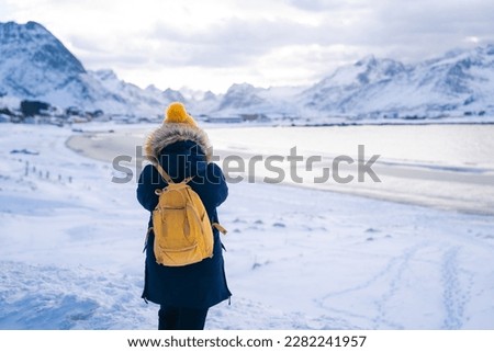 Girl travels around Lofoten Islands and takes pictures on camera. beautiful Norwegian landscape. Norway
