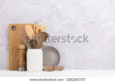 Kitchen utensils on wooden table. Front view with copy space