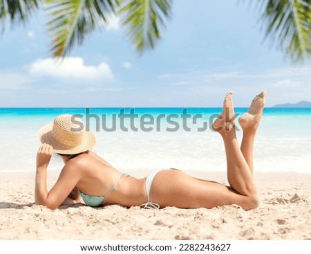 Woman in bikini on the tropical sea beach enjoying and relaxing in summer